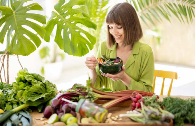 Una donna che mangia verdure da una ciotola