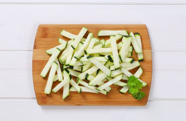 Zucchine tagliate e adagiate su un tagliere 