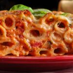 Piatto di ziti al forno con pomodoro e moozzarella