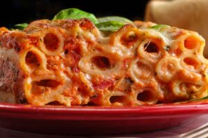 Piatto di ziti al forno con pomodoro e moozzarella