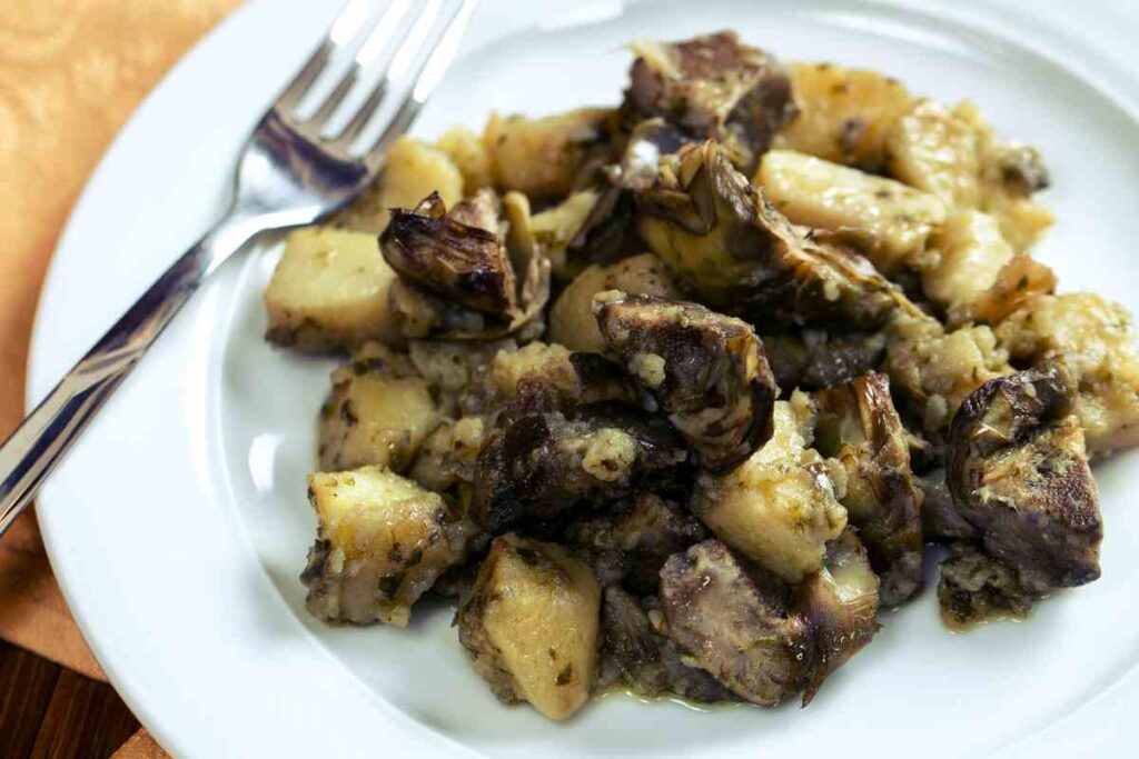 un piatto con patate e carciofi al forno visto dall'alto