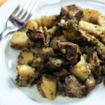 un piatto con patate e carciofi al forno visto dall'alto