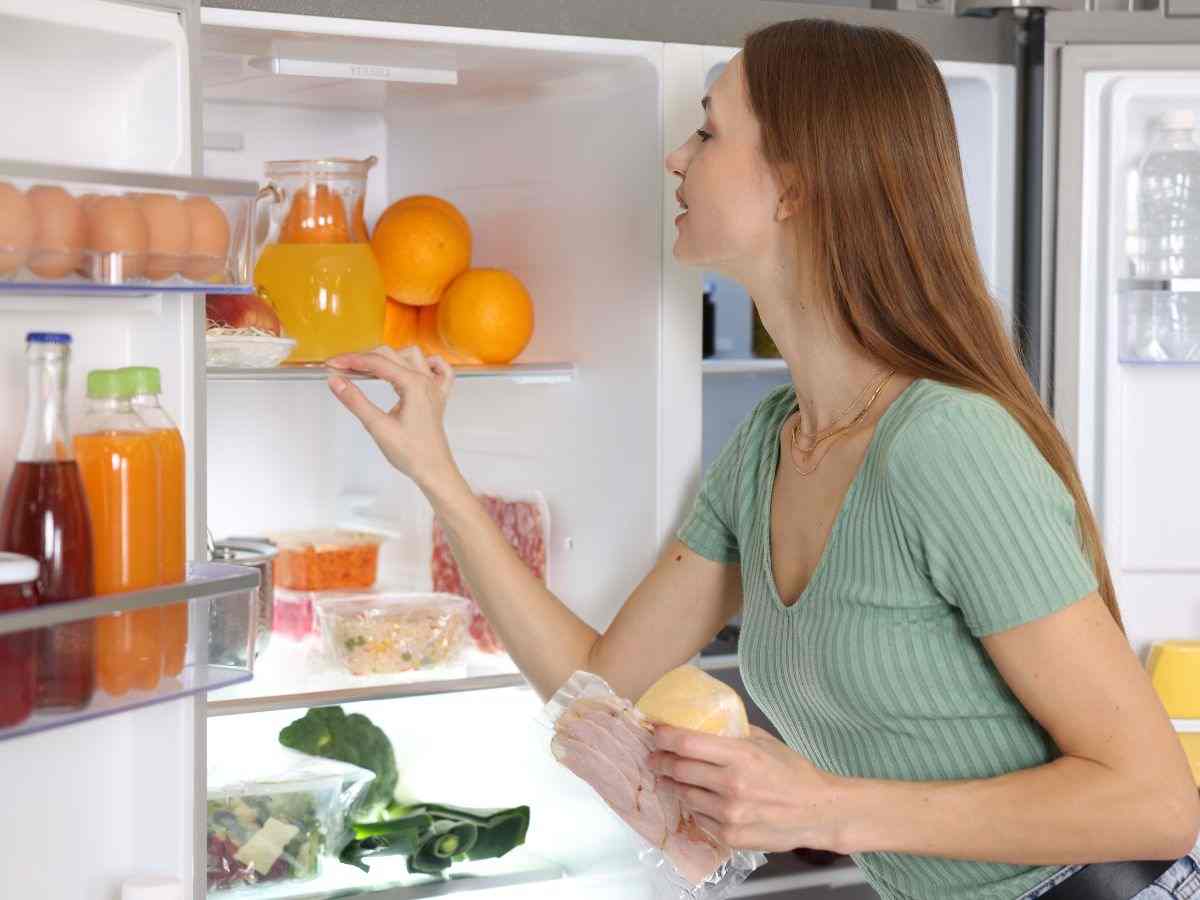 Donna che guarda in frigo